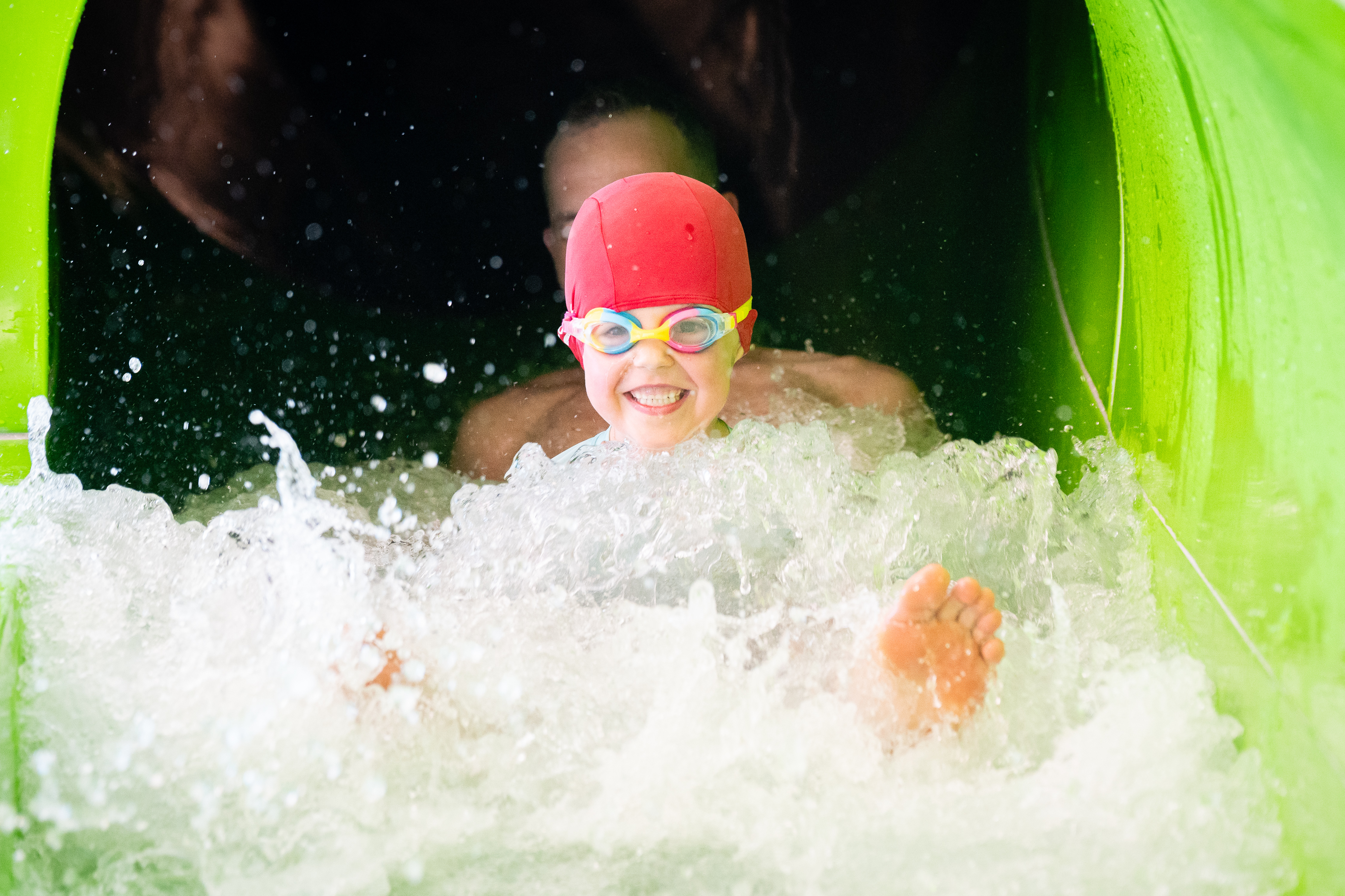 Child with goggles coming down zoom tube